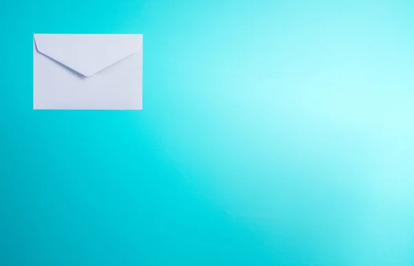 Valkoinen kirjekuori sinisellä pohjalla — kuvapankkivalokuva