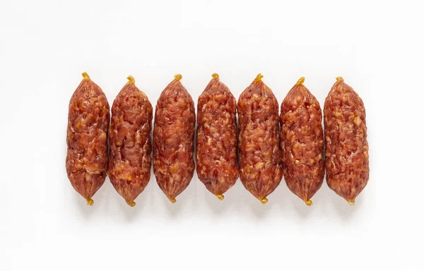 raw smoked mini sausages on a white background