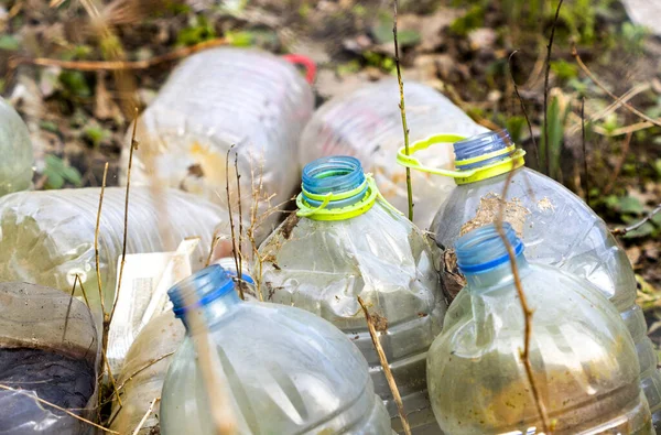 old empty plastic bottles in the grass, garbage in nature, environmental problems
