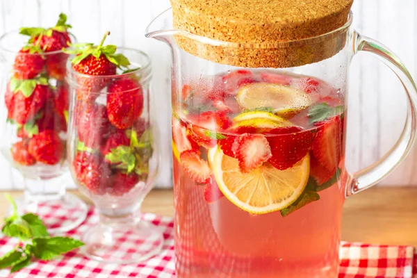 草莓和薄荷柠檬水放在有软木塞盖的玻璃瓶里，玻璃杯里放着新鲜草莓 — 图库照片