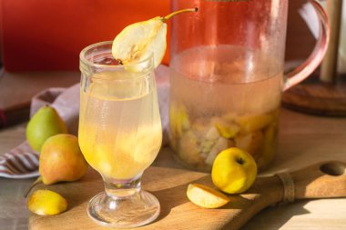 Bardakta armut kompostosu ve sürahi.