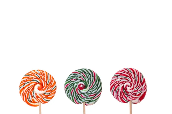 Drie veelkleurige ronde lolly 's op houten stokjes op een witte achtergrond — Stockfoto