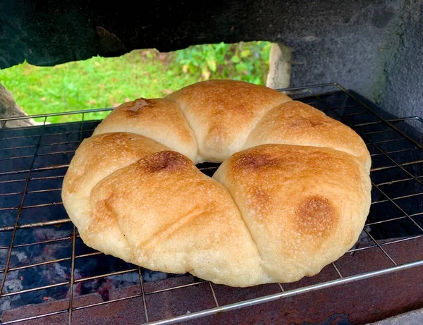 Круглый хлеб на гриле над углями, выпечка хлеба — стоковое фото