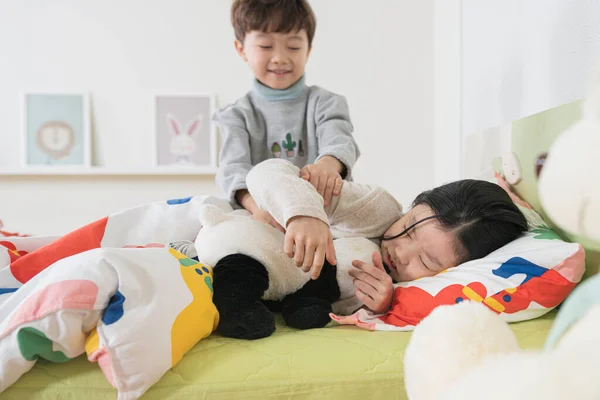 Asian young brother and sister children sleeping in bed