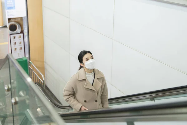 Yüz Maskeli Asyalı Bir Kadın Yürüyen Merdivende — Stok fotoğraf