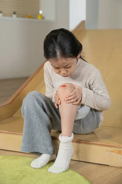 アジアの女の子とともに膝の上に傷によるスライド — ストック写真