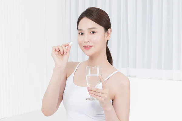 beautiful Asian Korean model holding vitamin pill, inner beauty concept