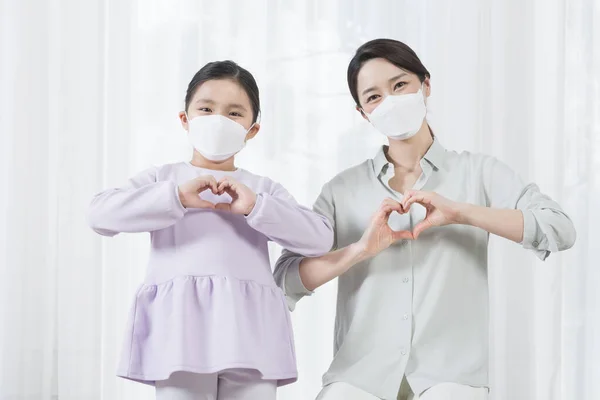 Asian mom and daughter wearing mask, covid virus safety concept