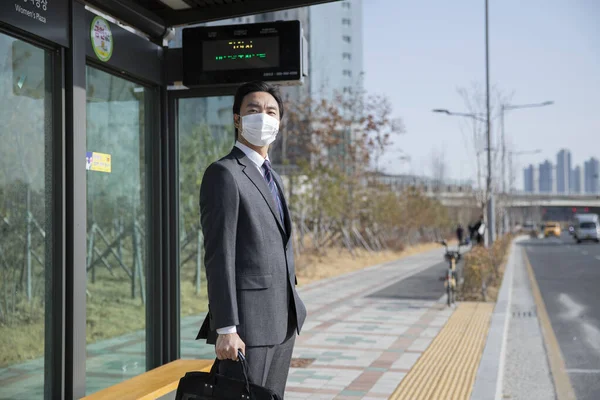 Otobüs Durağında Maske Takan Şık Takım Elbiseli Asyalı Bir Adam — Stok fotoğraf