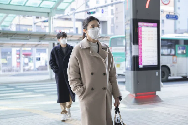 Asian man and woman with mask, crossing street