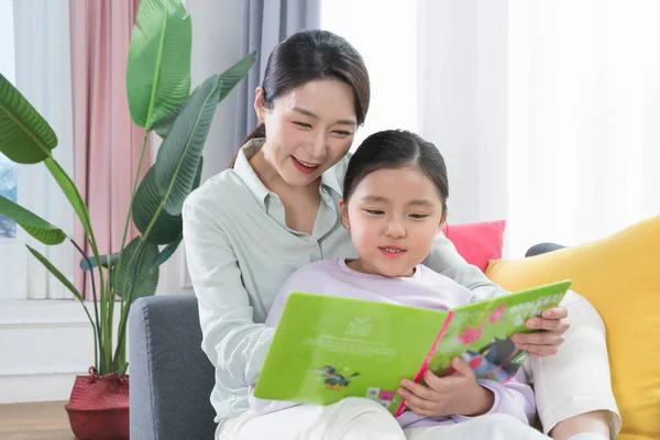 アジアの母親と若い娘読書本 — ストック写真