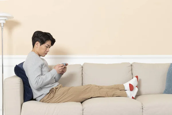 Asiatico Uomo Utilizzando Smart Phone Divano — Foto Stock