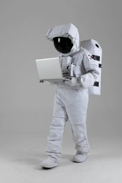 astronaut walking while using laptop computer device, white background