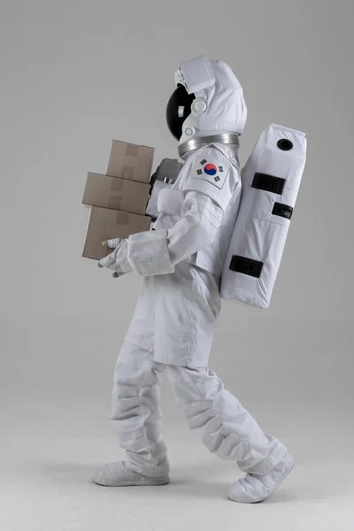 Αστροναύτης Περπατά Κρατώντας Ένα Κουτί Courier Λευκό Φόντο — Φωτογραφία Αρχείου