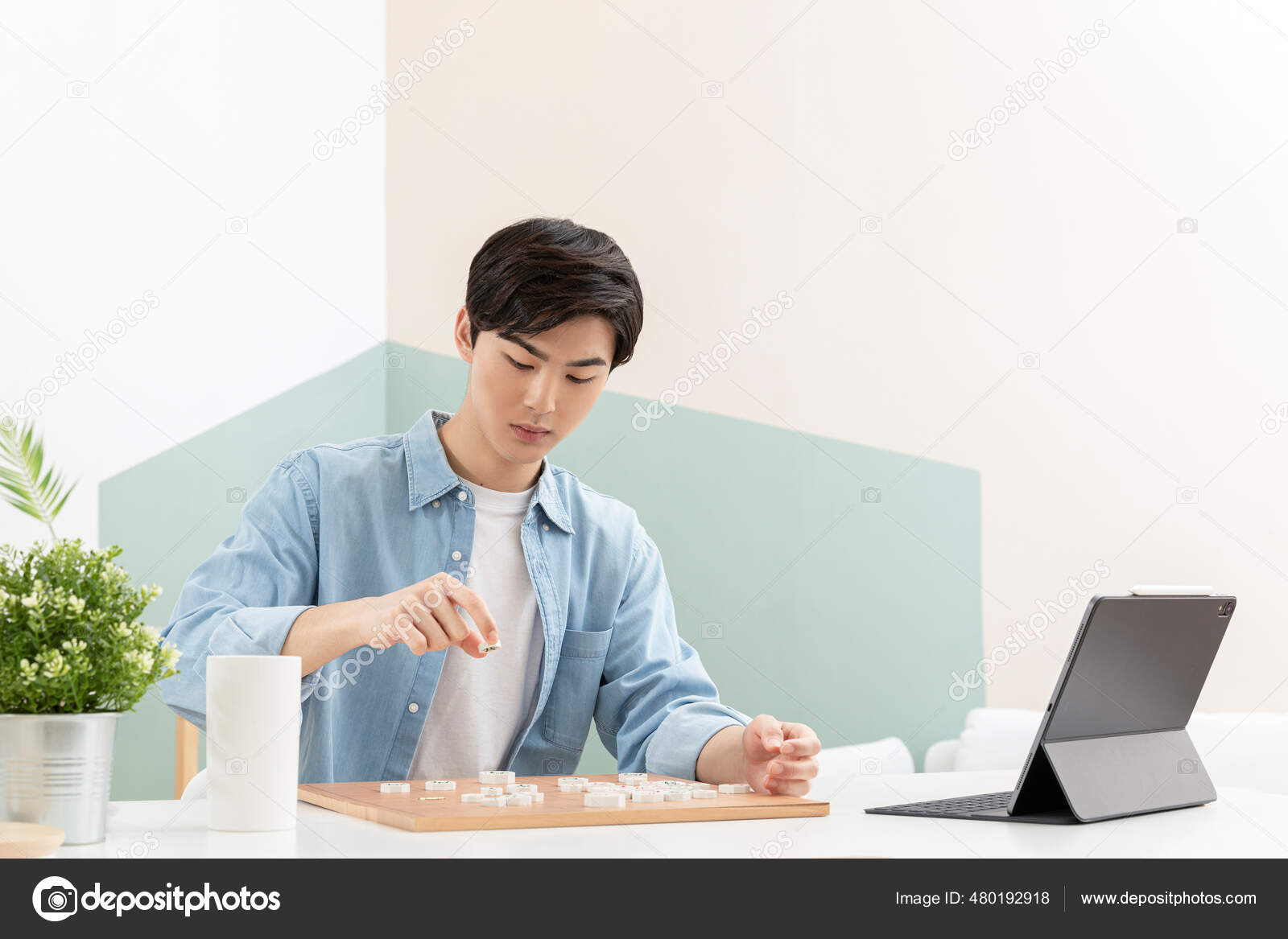 Man playing chess online on tablet computer Stock Photo