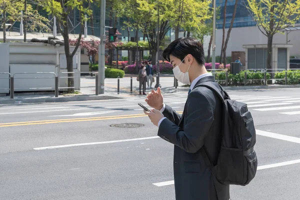 Asiático Joven Hombre Con Máscara Mirando Teléfono Inteligente — Foto de Stock