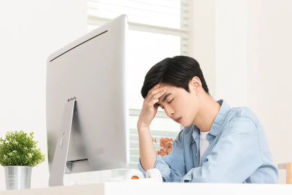 頭の悪いアジア系の若者がコンピュータの前に座り — ストック写真