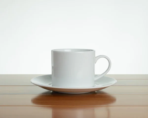 Taza blanca vacía con platillo sobre madera Imágenes De Stock Sin Royalties Gratis