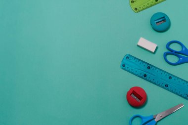 Yeşil arka planda çeşitli okul malzemeleri