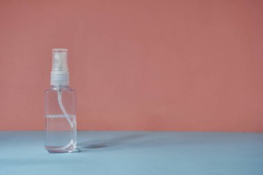 Alkol spreyi pembe ve gökyüzü mavisi arkaplanda