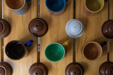 Farklı renkte kahve fincanları ve espresso kapsülünün hava manzarası.