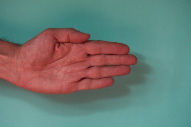 Sol el kağıt oyunu yapıyor. Taş, kağıt, makas, yeşil arka planda.