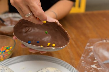 Paskalya yumurtasını çok renkli çikolata parçacıklarıyla doldur.