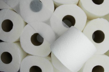 Beyaz tuvalet kağıdı rulosu diğer ruloların arka planında açılır.