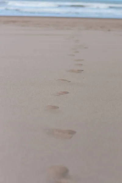 海滩上沙滩上的脚印 朝向大海的方向 — 图库照片