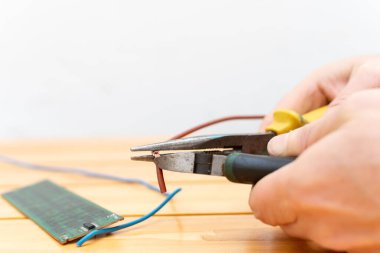 Kerpeten ve kerpetenle eller tamir için elektrik kablosunun korumasını kaldırıyor.