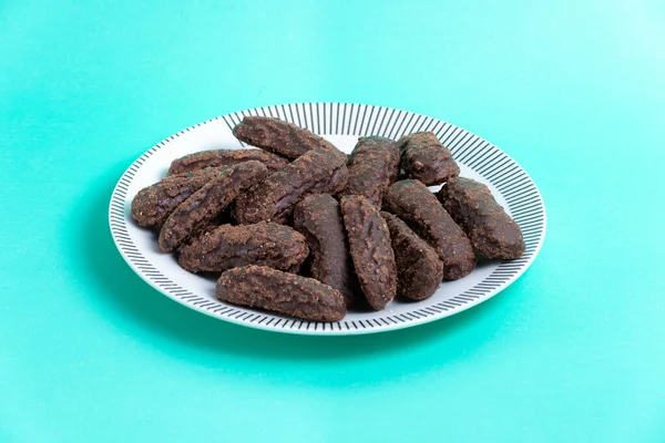 Turkuaz arka planda çikolata soslu kurabiye tabağı.