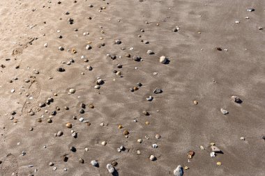 Kum dokusu deniz kıyısında çakıl taşlarıyla.