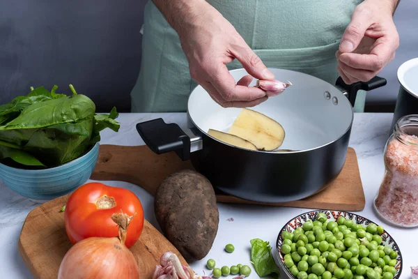 Yemek yapmak için diğer sebzelerin arasına sarımsak götürüyor..