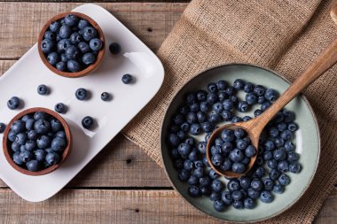 Farklı tabak ve kaselerdeki yaban mersinlerinin üst görünümü.