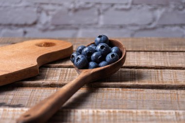 Yaban mersini dolu ahşap kepçe ve kopyalama alanı.