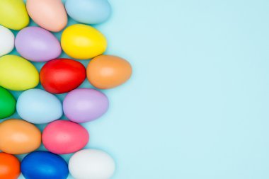 Pastel arka plan üzerinde renkli Paskalya yumurtaları