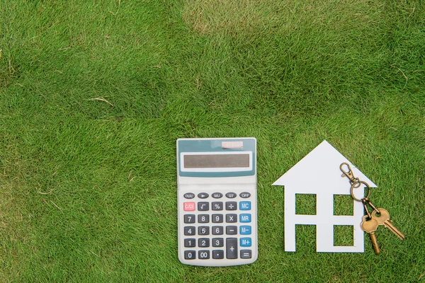 Casa con un ambiente hogareño, vida verde, calculadora de hipotecas — Foto de Stock