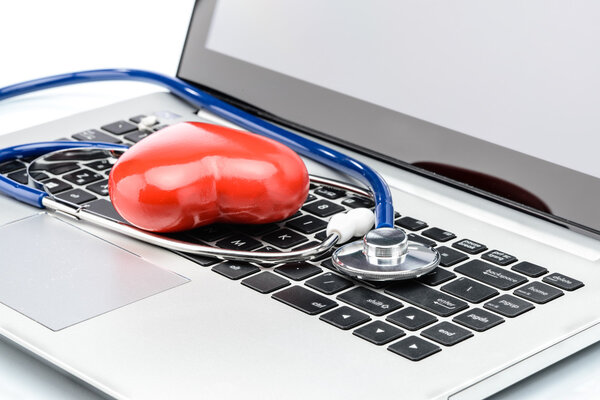 Heart disease research, stethoscope and heart shape on laptop ke