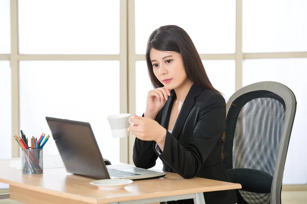 Молодая азиатская бизнесвумен думает в офисе — стоковое фото