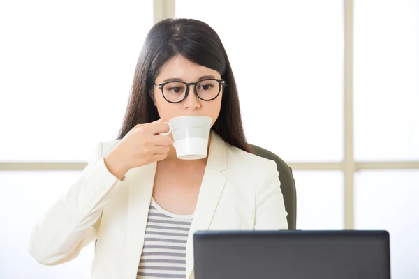 Mulheres de negócios asiáticas trabalhando e bebendo café no laptop — Fotografia de Stock