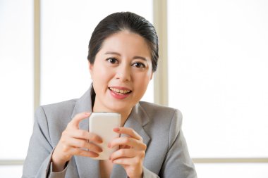 Gülümseyen ve akıllı telefon metin messagi kullanarak güzel Asyalı kadın