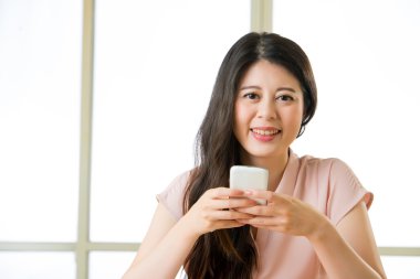 Güzel genç Asyalı kadın akıllı telefon kısa mesaj kullanarak