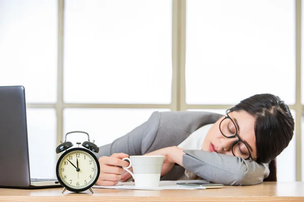 Уставшая женщина спит и держит кофе — стоковое фото