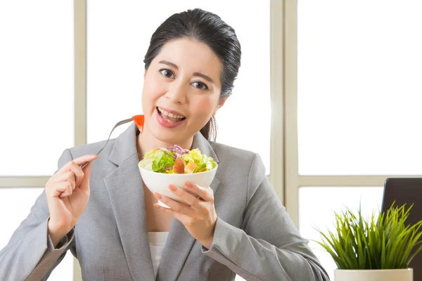 Jovem mulher de negócios asiática desfrutando de uma salada saudável — Fotografia de Stock