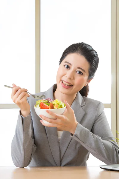 Jovem mulher de negócios asiática desfrutando de uma salada saudável — Fotografia de Stock