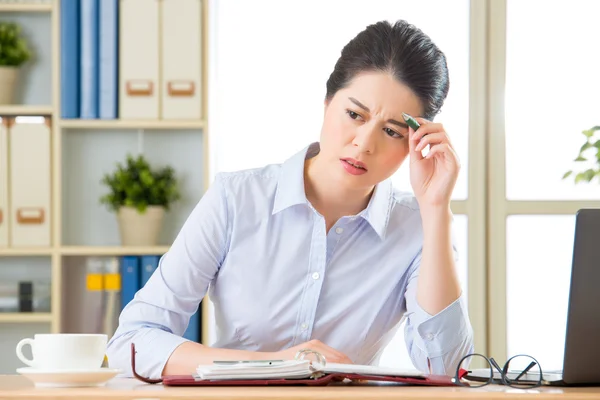Junge asiatische Geschäftsfrau schreibt mit Kopfschmerzen — Stockfoto