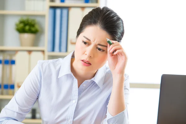 Junge asiatische Geschäftsfrau schreibt mit Kopfschmerzen — Stockfoto