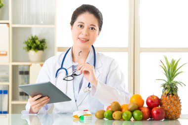 Genç Asyalı beslenme uzmanı doktor dijital tablet kullanma