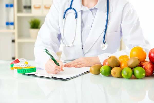 Jovem asiático nutricionista médico escrevendo plano de dieta — Fotografia de Stock