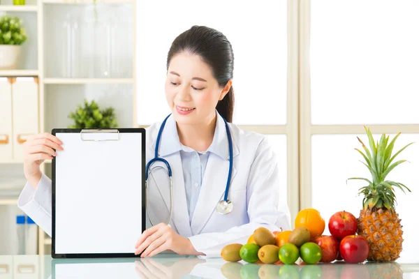 Dokter voedingsdeskundige met vruchten en bedrijf leeg Klembord — Stockfoto